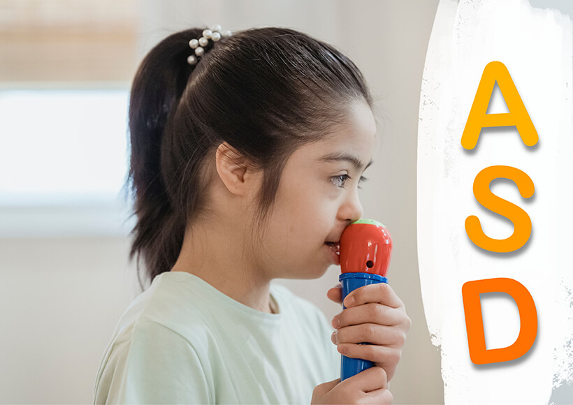 A child with mild Down syndrome holding a toy microphone, with the letters ASD down the right-hand side of the image