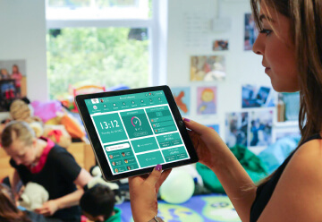 Sara thakrar holding using Blossom Educational app on tablet