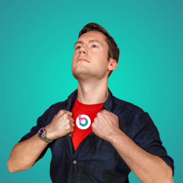 A headshot of Stuart Thomas, opening his shirt to reveal the Blossom logo beneath