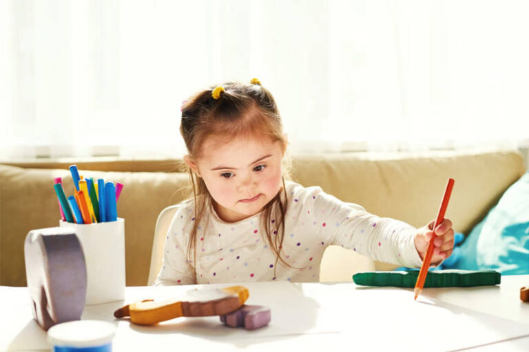 A child drawing intently on a white table, expressing their artistic talents