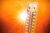 A thermometer graphic with a sun blazing behind it