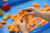 Children's hands playing with orange-coloured sand