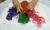 A young person's hands playing with coloured spaghetti or noodles, like lace sweets