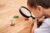 Child with magnifying glass looking at fake insects