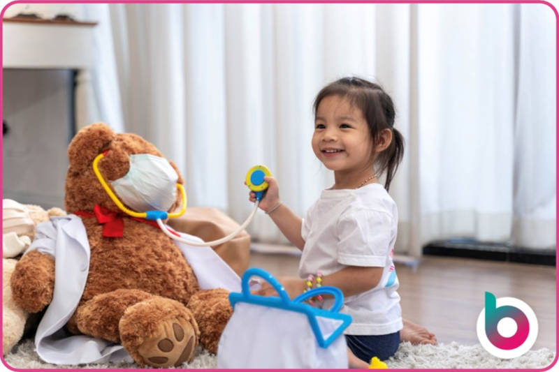 A child administering early years first aid to a teddy bear