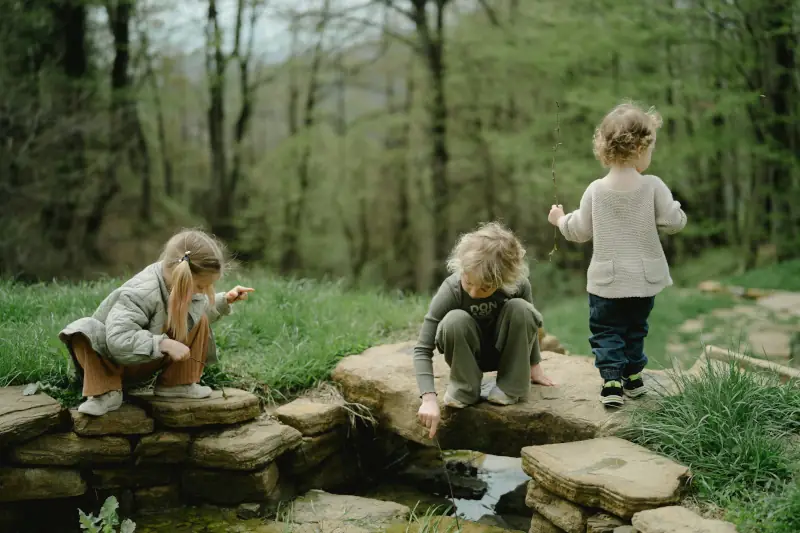 Forest school image - Children playing by a brook or small pond