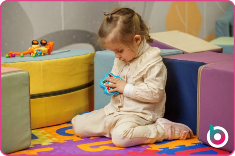 Child playing with a fidget spinner in a soft play area