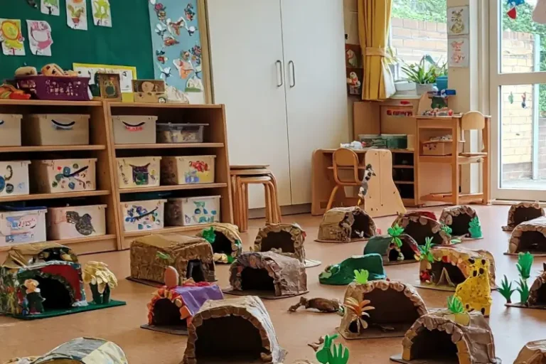 A collection of cardboard caves on the floor of a nursery or schoolroom
