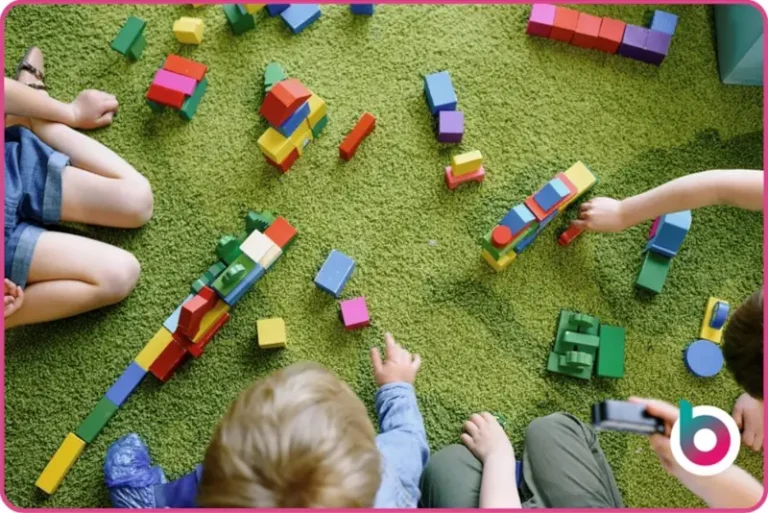 Children playing with blocks on green carpet