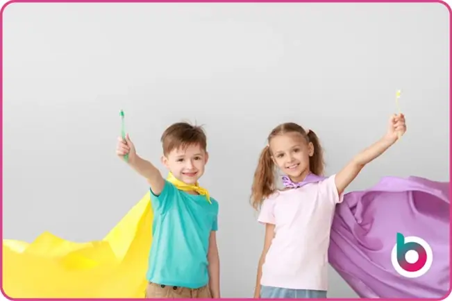 children with toothbrushes in their hands and capes on