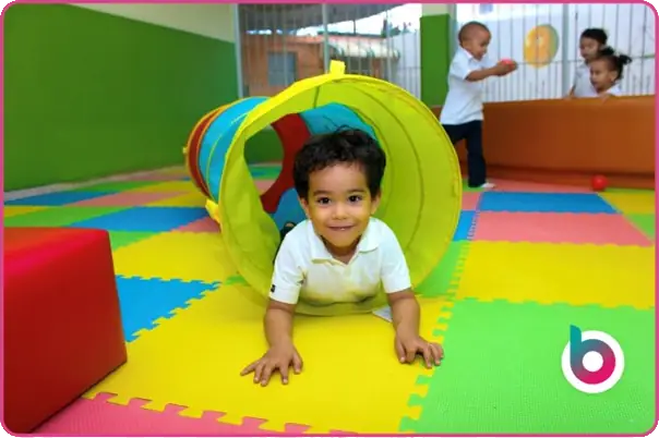 a child crawling out of a colourful pop tunnel
