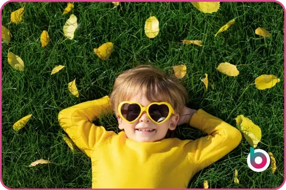 child wearing sunglasses lying on grass