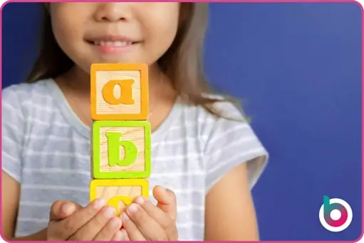a child holding letter blocks
