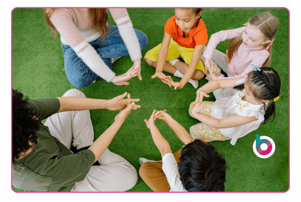 A group of children sitting on the floor with their hands in a circle doing an SEMH intervention
